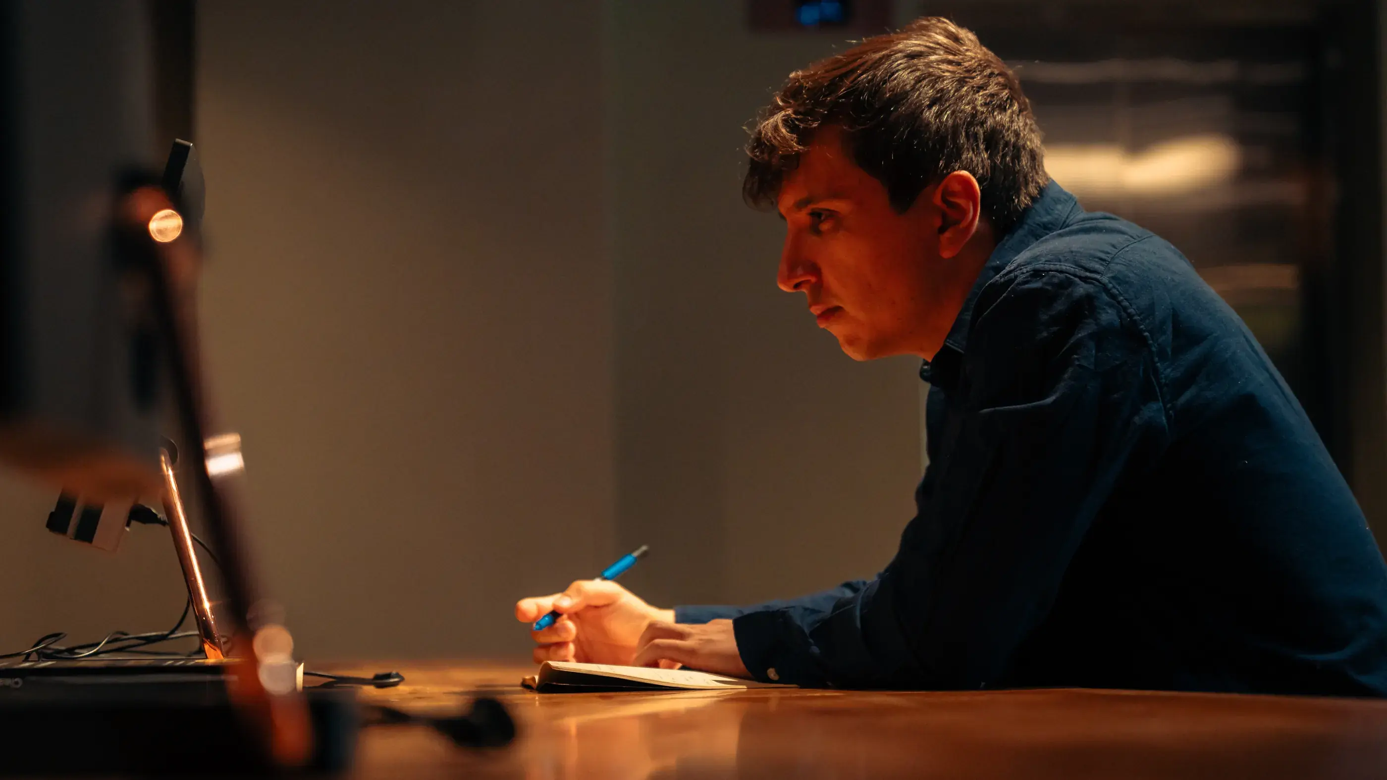 Matías Gajardo trabajando de noche frente a su escritorio, tomando notas